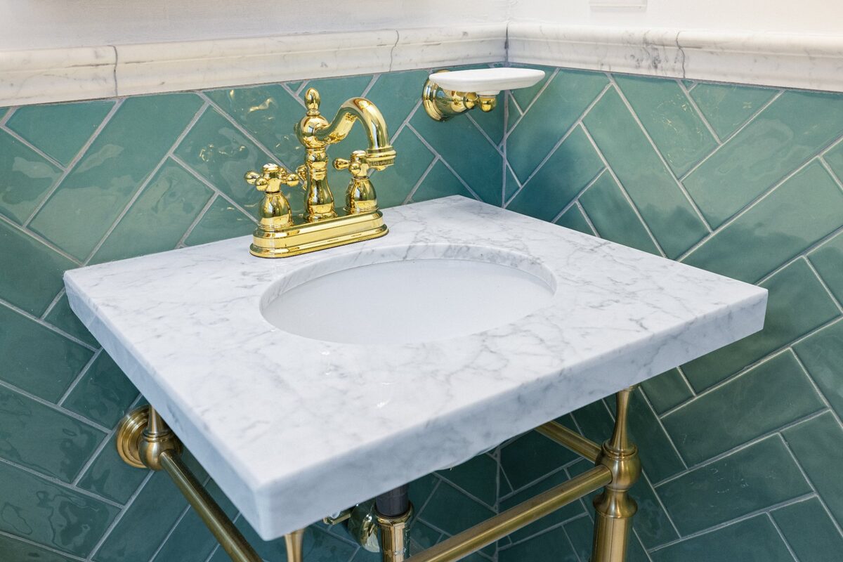 Carrara marble console sink with brass legs and cross-handle faucet — Butler, MD