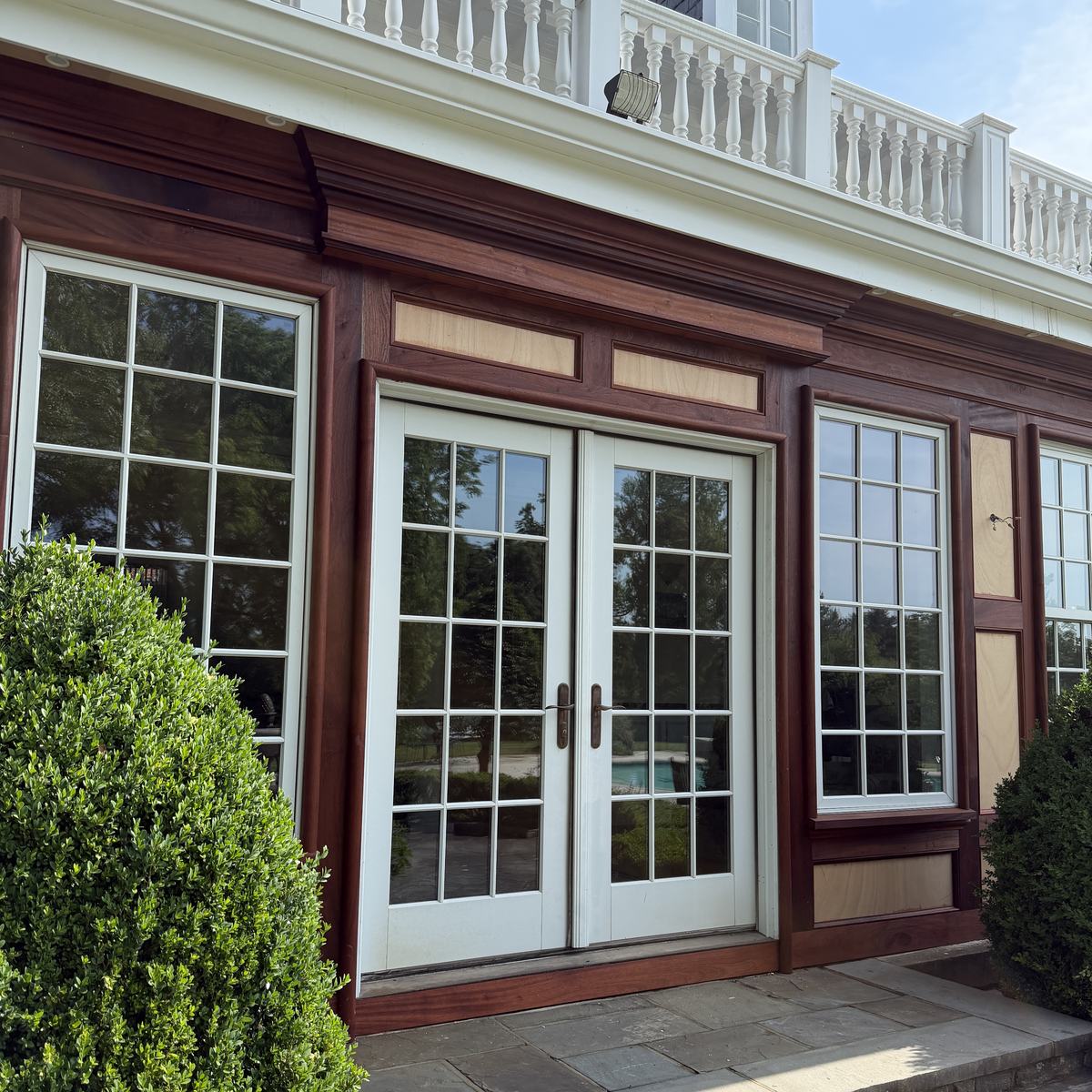 Close view of hand-fitted sapele window casings and panel framing around new French doors — North Winds Porch, Towson