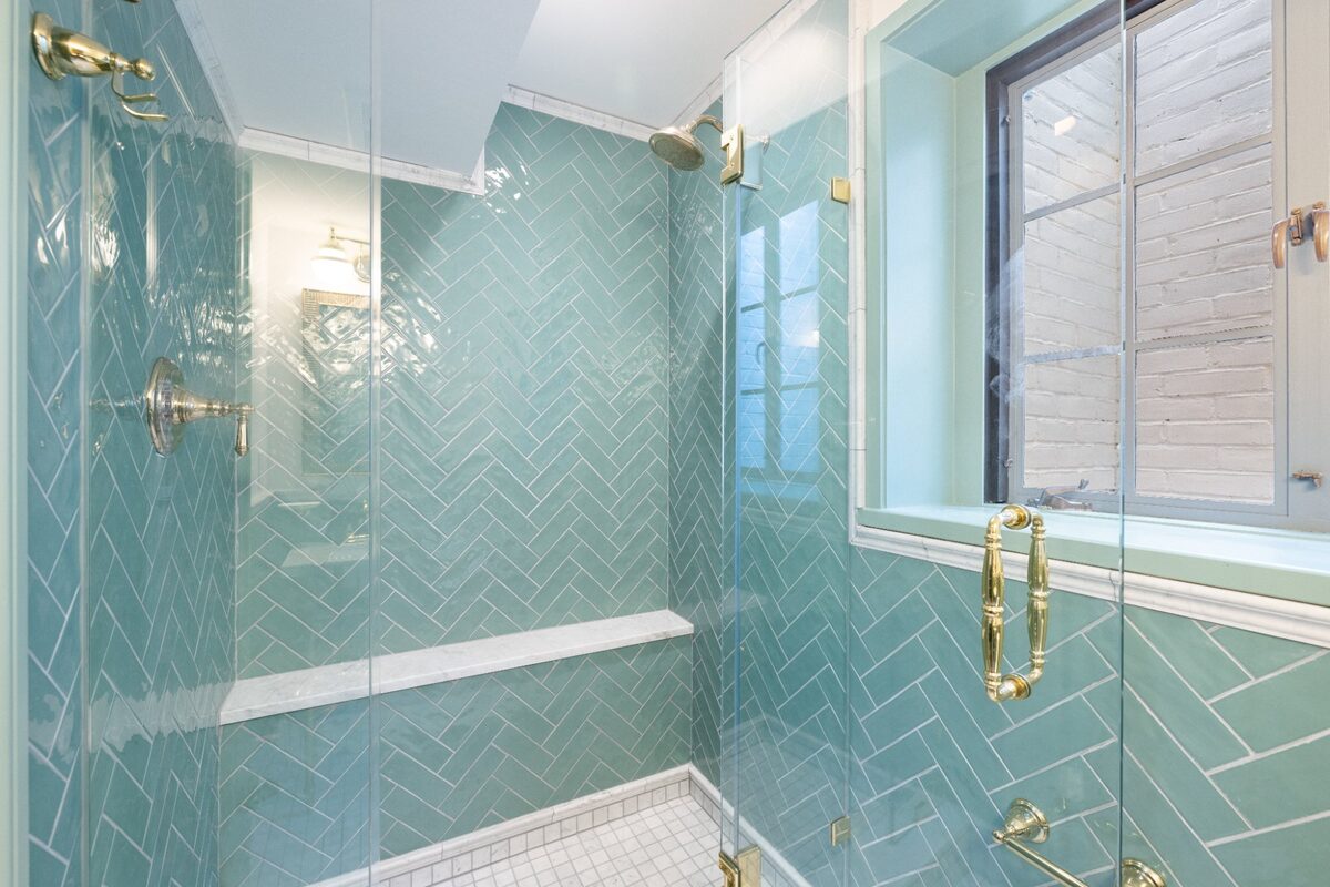 Walk-in shower with floor-to-ceiling herringbone tile and marble shelf — Butler, MD