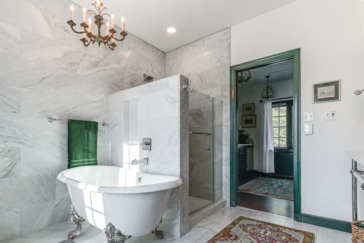 Marble bathroom with clawfoot tub, chandelier, and glass shower partition — Hunt Valley