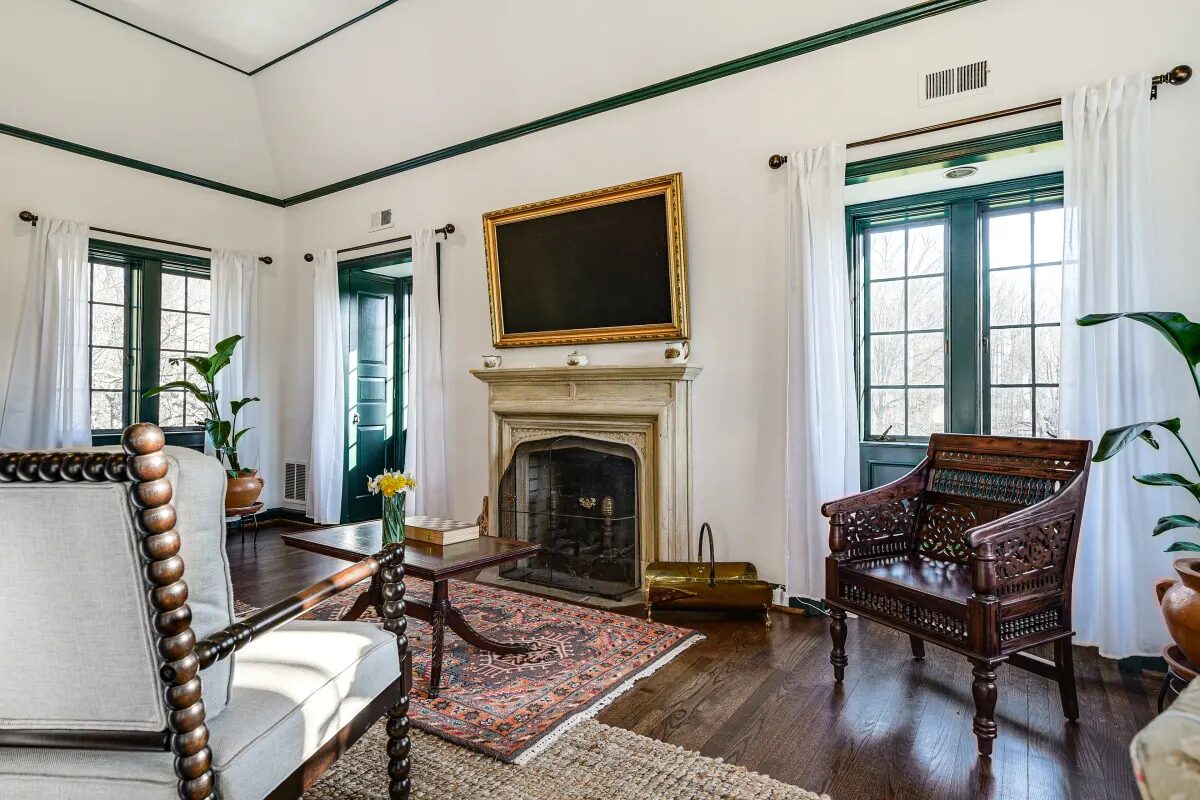 Stone fireplace with carved wooden chair and oriental rug — Hunt Valley